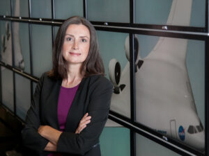 Karen Willcox in front of monitors with rocket pictured